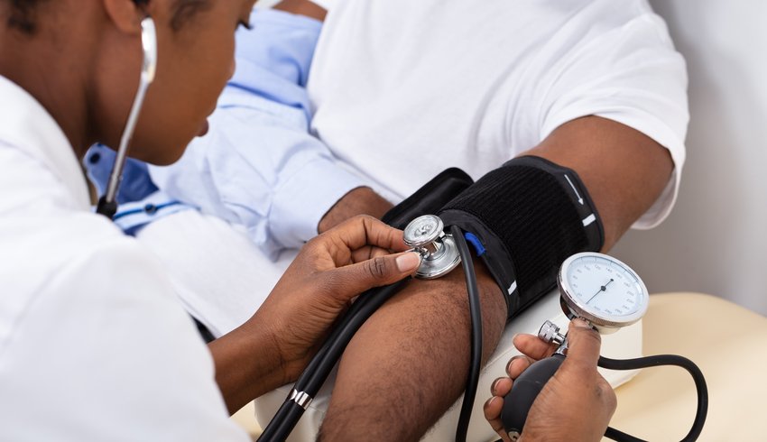 Doctor measuring a patient's blood pressure using a cuff.