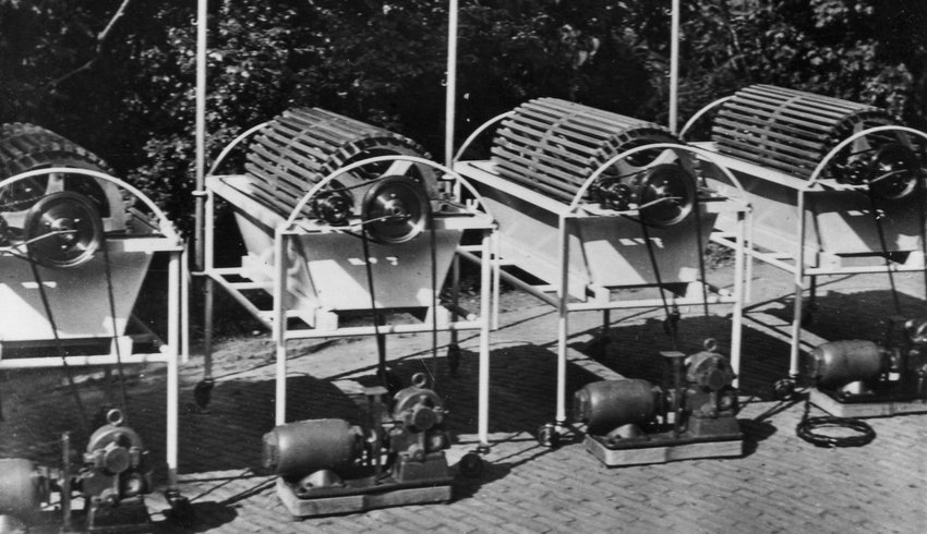A black and white photograph of four early haemodialysis machines invented by Dr Kolff, outdoors.