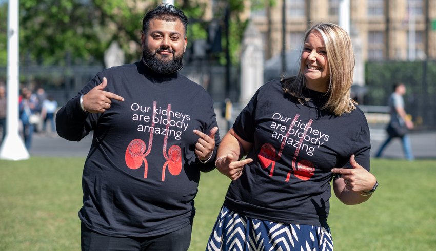 Two people wearing Bloody Amazing Kidneys campaign T-shirts with the wording 'Our kidneys are bloody amazing' outside Parliament.