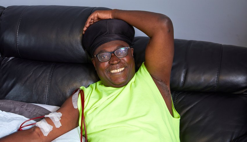 Photo of Enoch, reclined on a sofa with haemodialysis line inserted