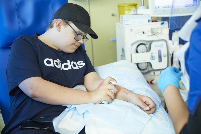 Teenager using numbing spray on arm