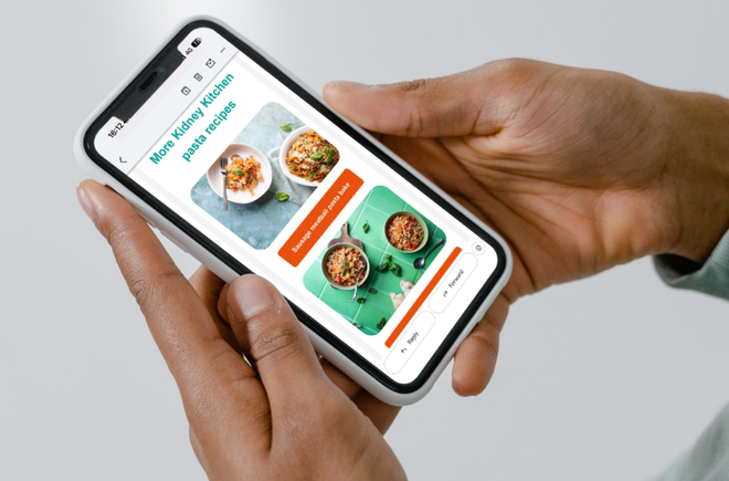 Hands holding a phone with the Kidney Kitchen email displayed on the screen