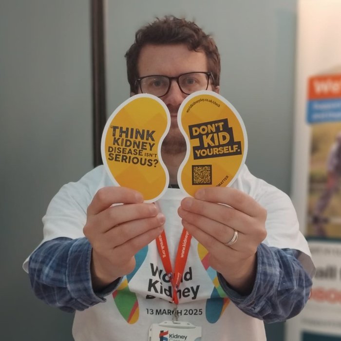 Kidney Care UK staff member holding up World Kidney Day 2025 paper kidneys