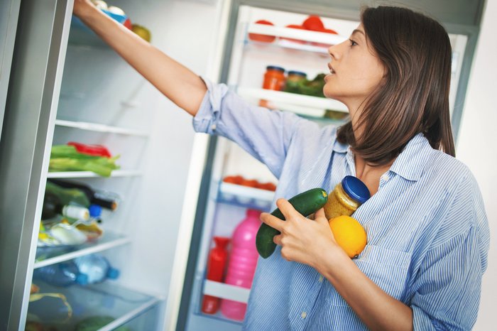 Woman choosing food in fridge