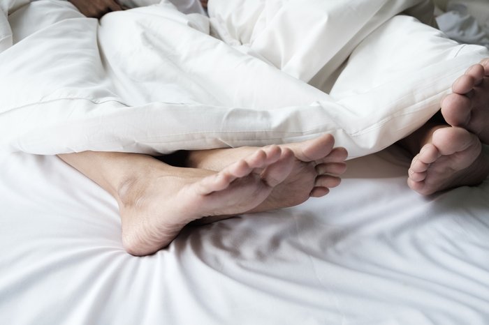 Feet of a couple in bed